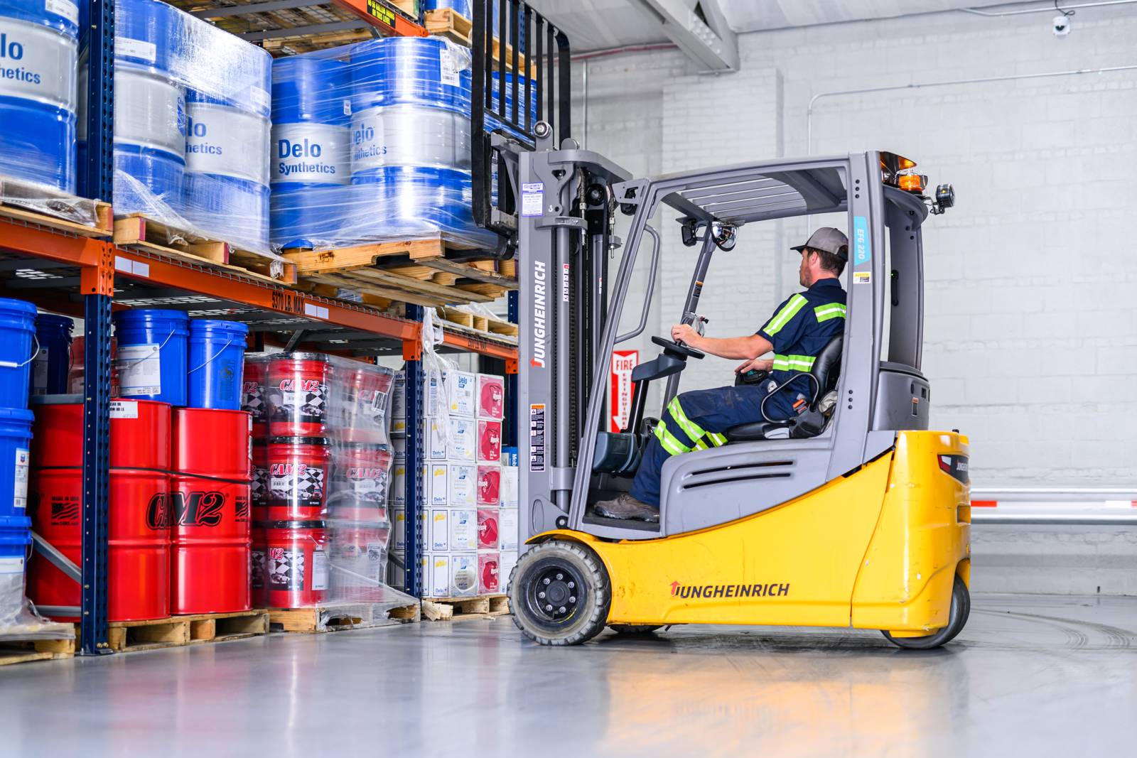 Forklift moving lubricant drums in the warehouse