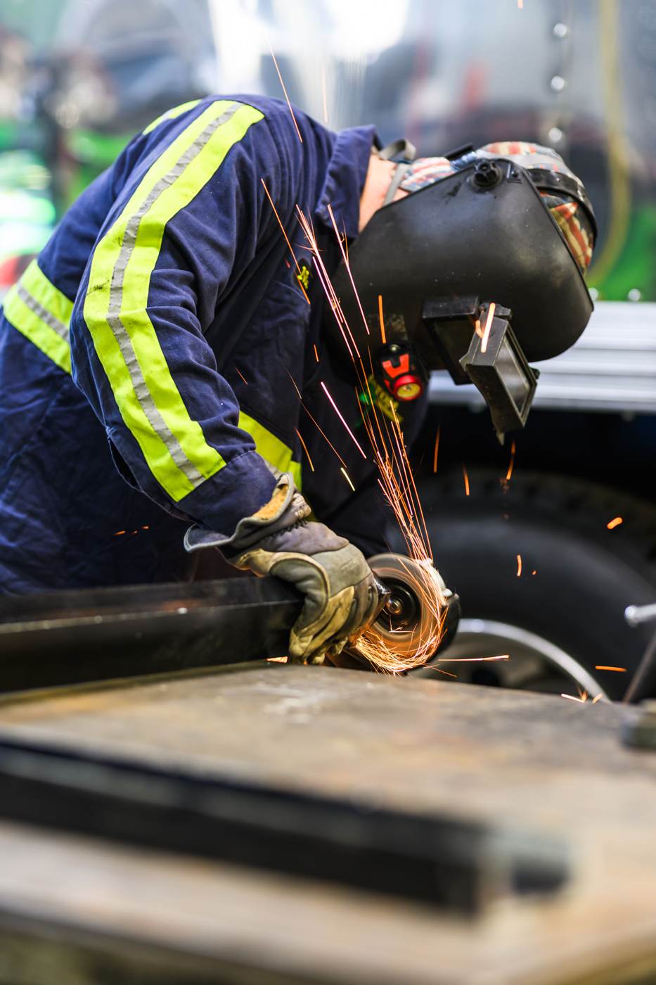 Shop technician grinding steel in the maintenance bay