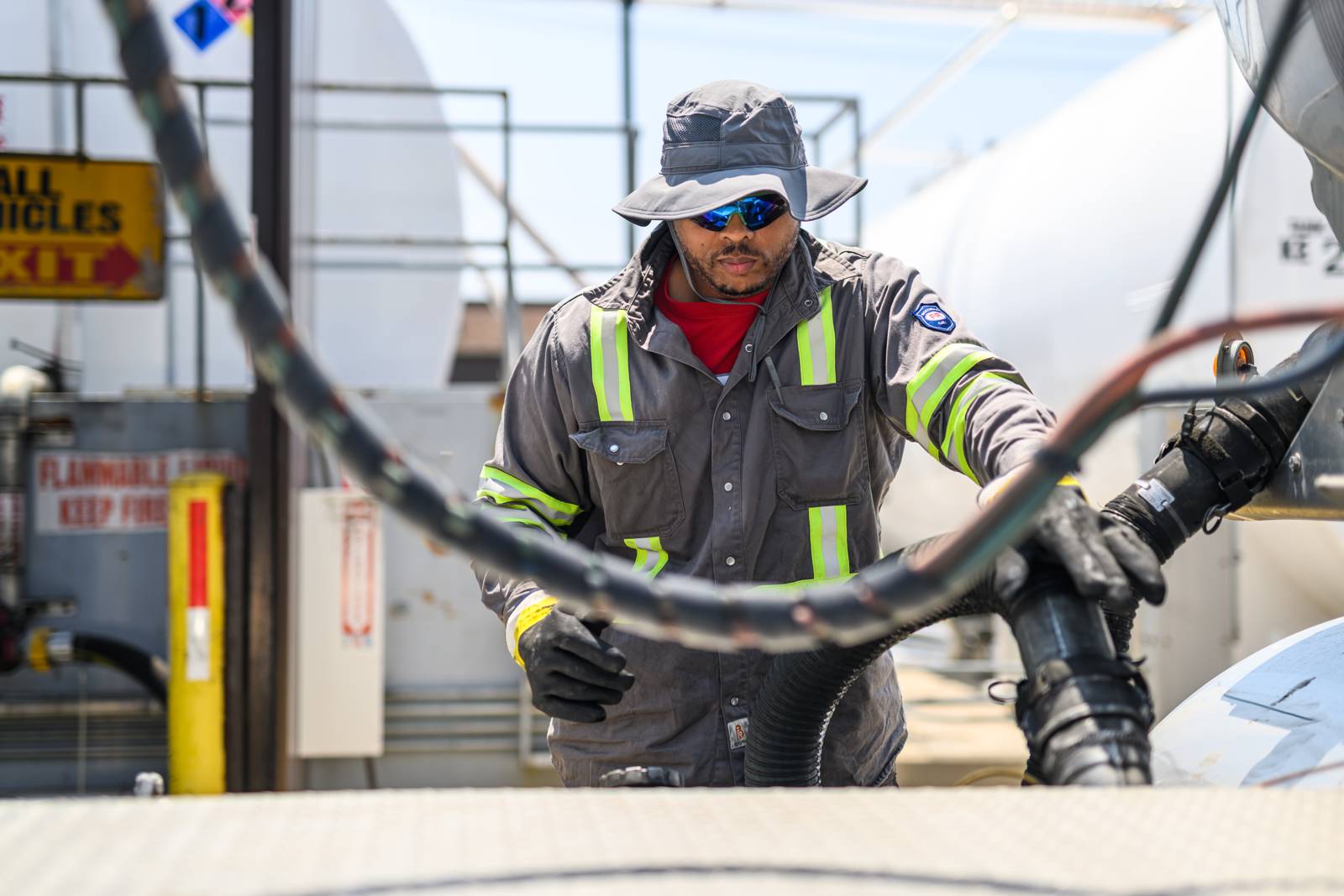 Warren technician handling a transfer hose at the tank farm